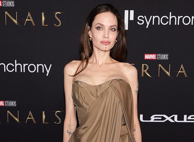 Золотой кафф на подбородке и песочное платье-простыня — Анджелина Джоли выбрала эффектный лук для ковровой дорожки
