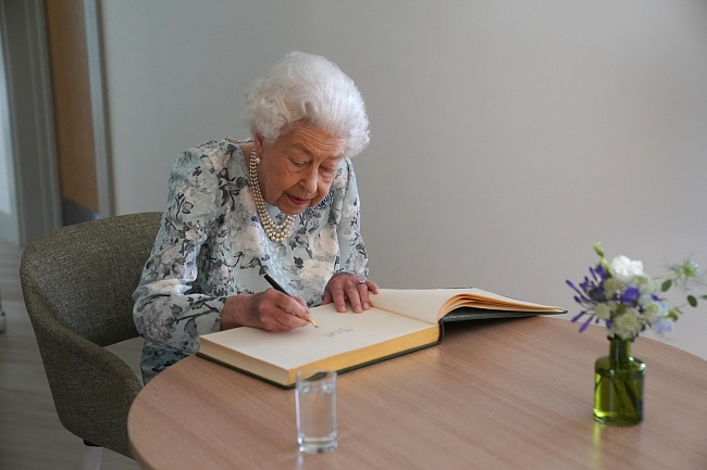 Елизавета II подписывает гостевую книгу во время визита в хоспис фото № 2