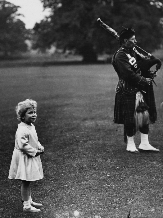 Принцесса Елизавета (будущая королева Елизавета II) наблюдает за игрой трубного оркестра на территории замка Глэмис в Шотландии, сентябрь 1929 года фото № 2