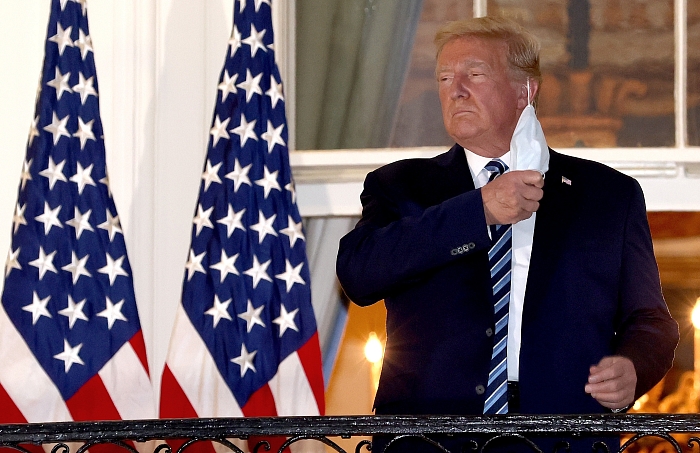 5 октября 2020 года, президент США Дональд Трамп снимает маску по возвращении в Белый дом из Национального военно-медицинского центра Уолтера Рида, где он проходил терапию после перенесенного Covid-19 фото № 9